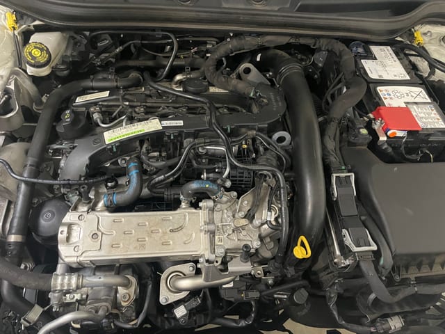 Mobile mechanic working on a Mercedes AMG engine bay in a Brisbane driveway with a diagnostic laptop connected.