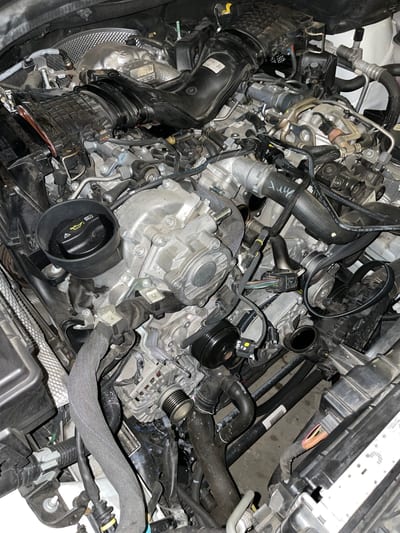 Diagnostic scan tool plugged into a Mercedes AMG showing fault codes on a laptop screen.